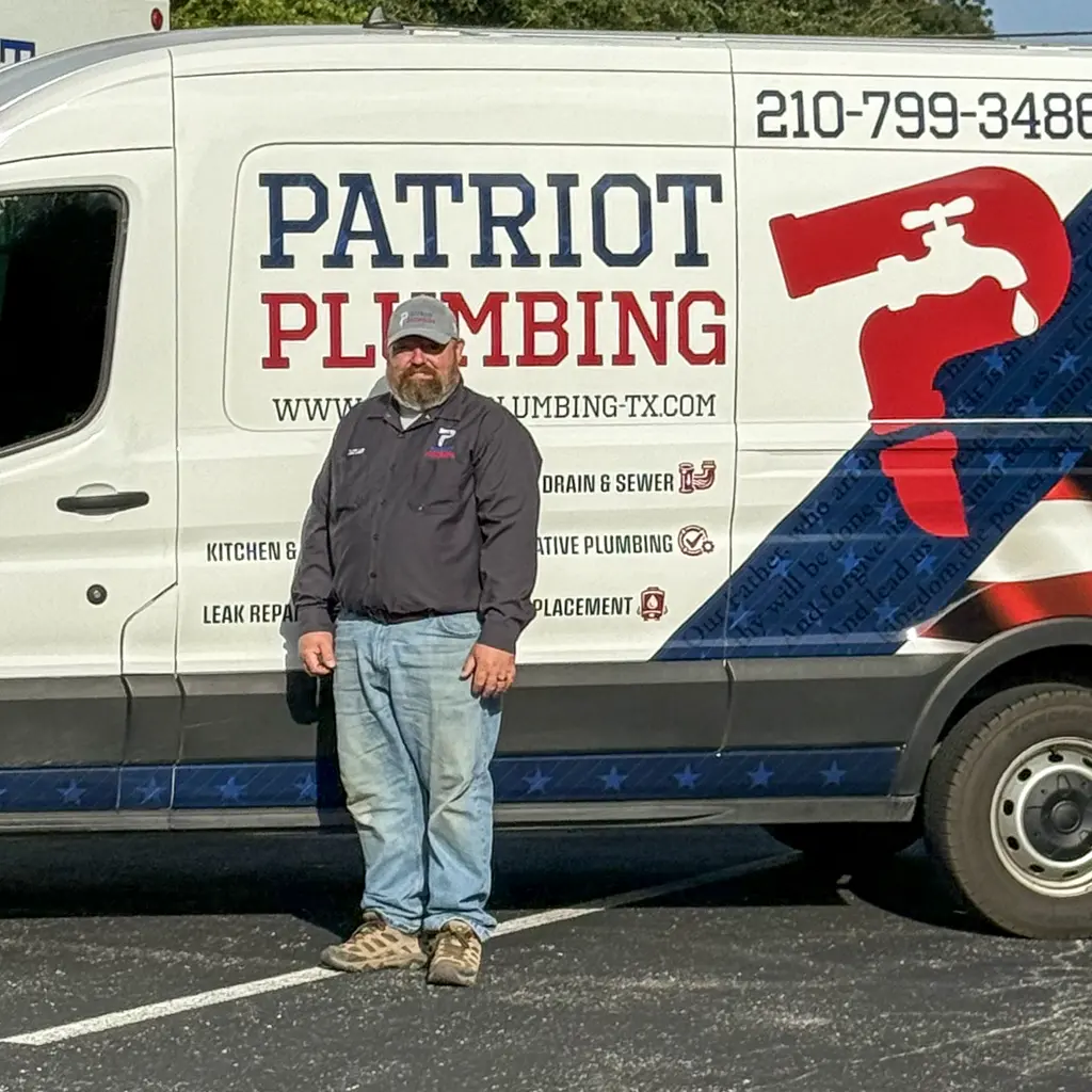 San Antonio, Texas plumber standing beside a Patriot Plumbing work van listing drain, sewer, and leak repair services