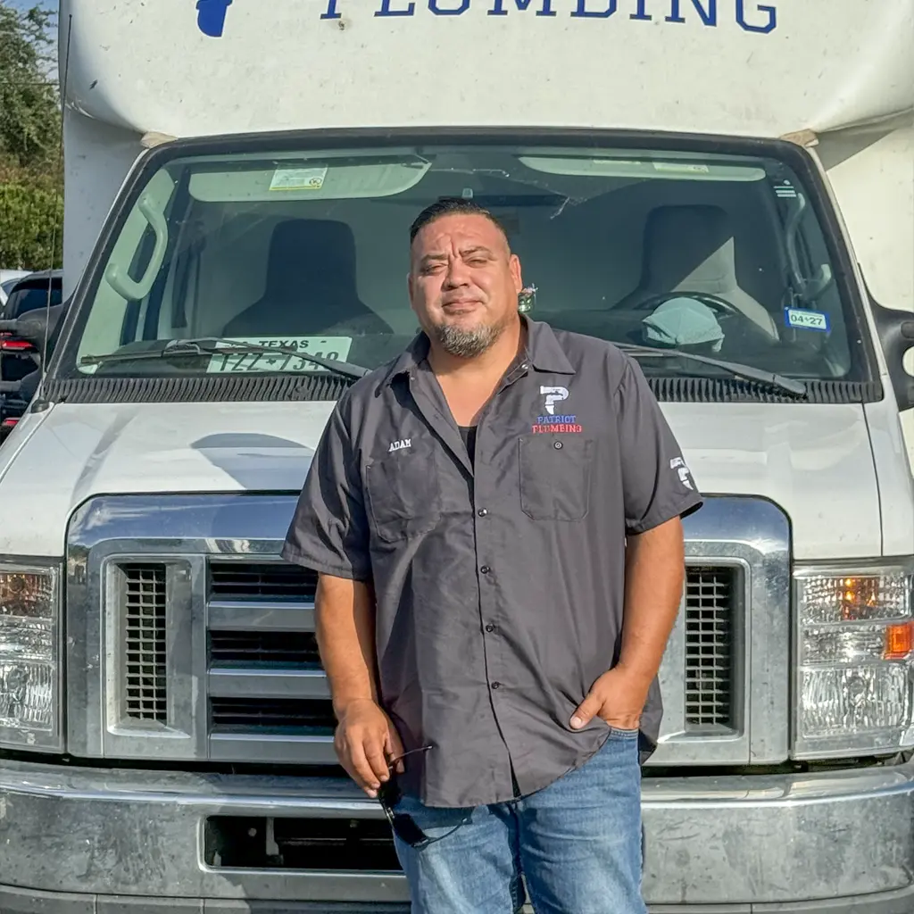San Antonio plumber standing in front of a Patriot Plumbing work truck before a service call
