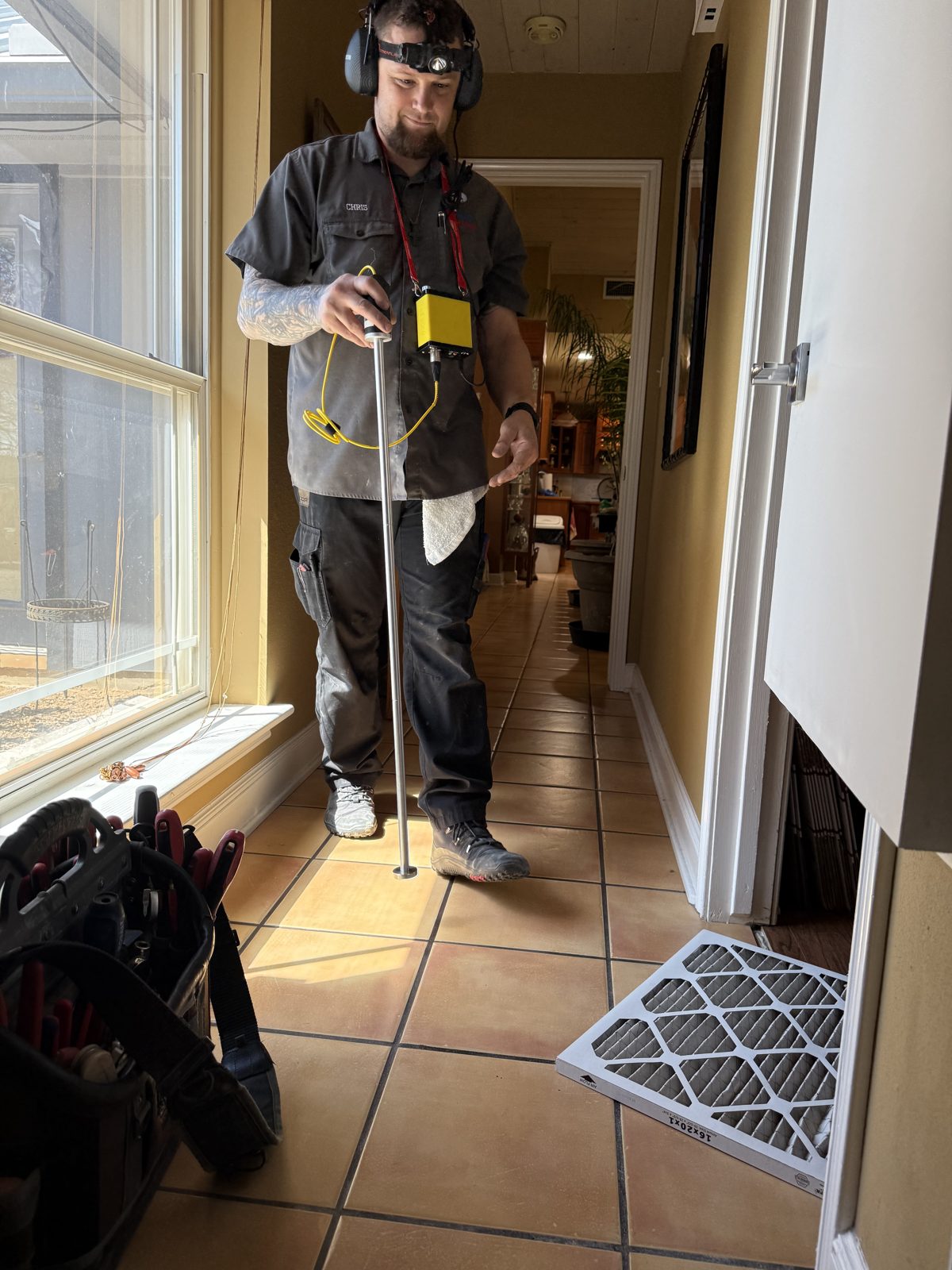 Chris McAnear using a pipe and line locator during a plumbing service call in San Antonio, TX
