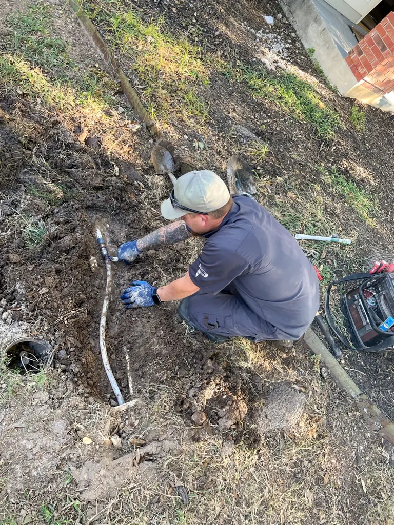 San Antonio plumber repairing outdoor water line and sewer connection