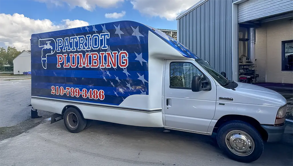 Patriot Plumbing service vehicle with American flag design parked outside San Antonio TX workshop - licensed plumbers serving the greater San Antonio area